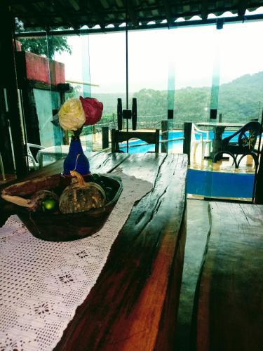 a vase sitting on a wooden table with a vase at Bistrô Pousada Savacipó in Serra do Cipo