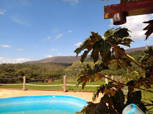 a view of a swimming pool with mountains in the background at Bistrô Pousada Savacipó in Serra do Cipo