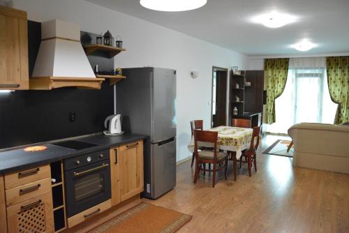 a kitchen with a refrigerator and a table with chairs at Guest House Mimosa in Balchik