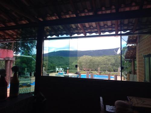 a large window with a view of a swimming pool at Bistrô Pousada Savacipó in Serra do Cipo