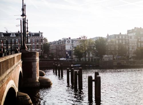 a bridge over a body of water with buildings at SWEETS - Nieuwe Amstelbrug in Amsterdam