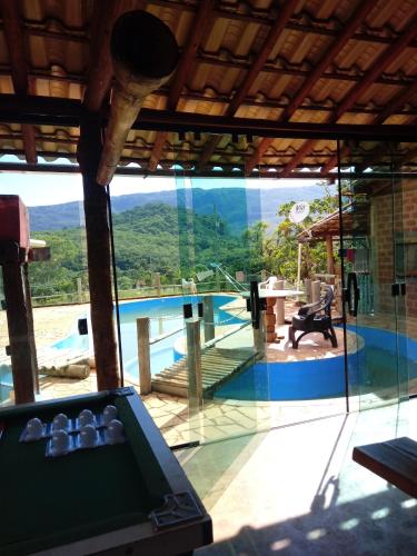 a room with a pool and a large glass window at Bistrô Pousada Savacipó in Serra do Cipo