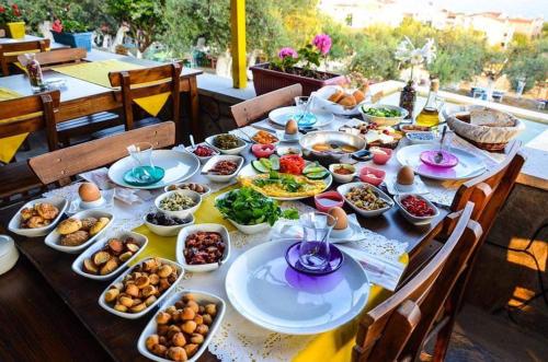 una mesa con platos de comida en la parte superior en Kaymak Tepesi Tatil Evi en Kucukkuyu