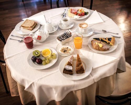 a white table with plates of breakfast food on it at Grand Hotel Italia in Orvieto