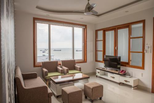 a living room with a couch and a tv at Sao Mai Hotel & Apartment in Vung Tau