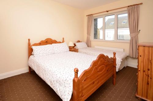 a bedroom with two beds and a window at Cottage 323 - Cleggan in Cleggan