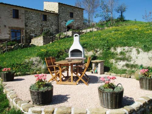a patio with a table and chairs in front of a house at Agriturismo Carincone in Pergola