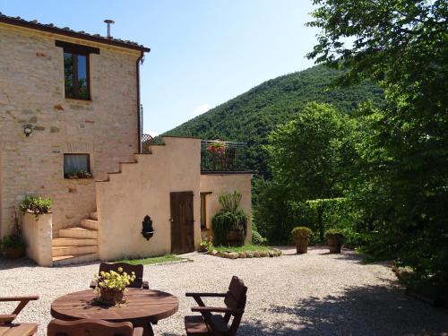 a building with a table and chairs in a courtyard at Agriturismo Carincone in Pergola