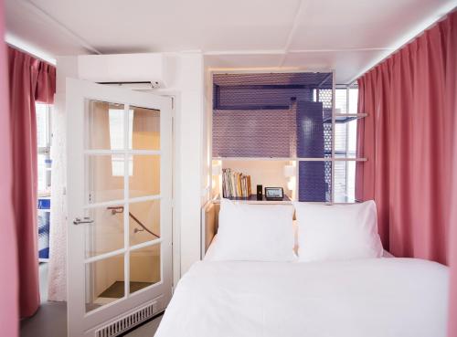 a bedroom with a white bed and a window at SWEETS - Westerdoksbrug in Amsterdam