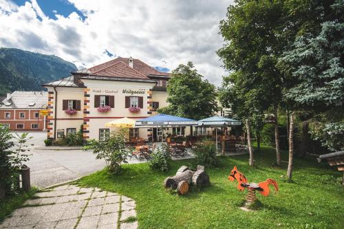 a large building with a yard with a house at Hotel-Gasthof Weitgasser in Mauterndorf