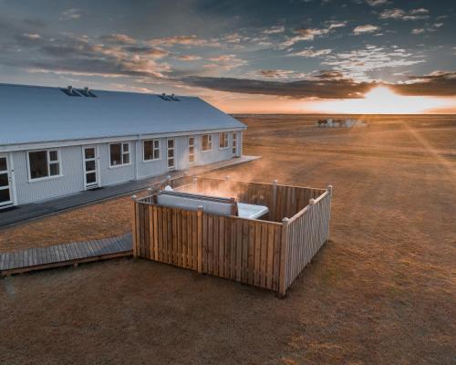 a building in the middle of the desert with the sunset at Hotel Vos in Hella