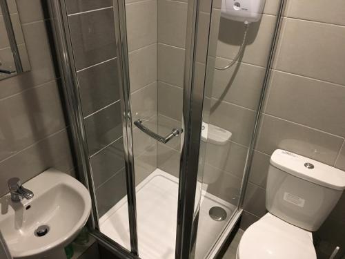 a bathroom with a sink, toilet and shower stall at West Port Hotel in Linlithgow
