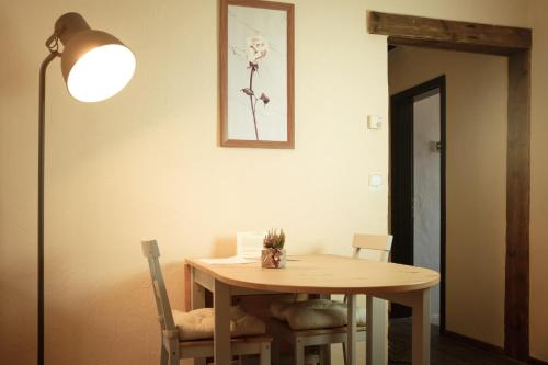 a dining room table with a lamp and a table and chairs at moments café & apartmenthaus in Thurnau
