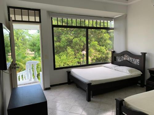 a bedroom with a bed and a large window at Casa Girardot Condominio El peñon 5 Habitaciones. in Girardot