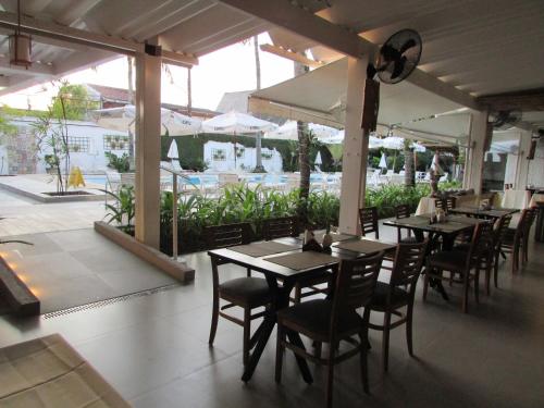 a dining room with tables and chairs and a patio at Ubatuba Palace Hotel in Ubatuba