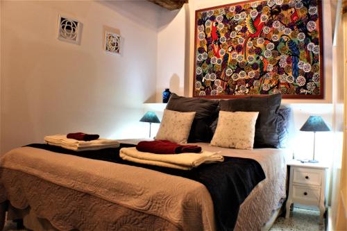 1 dormitorio con 1 cama con una pintura en la pared en Il nido nascosto, en Lucca