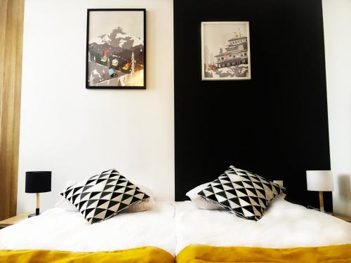 a bedroom with a bed with black and white pillows at Stacja 605 in Karpacz