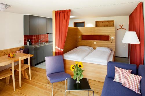 a small apartment with a bed and a table and chairs at Hapimag Ferienwohnungen Andeer in Clugin