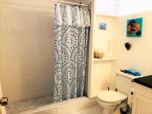 a bathroom with a shower curtain and a toilet at Opp Sea, Beach, Restaurants 5b - 2bed 2 bath 5B Hastings Tower in Bridgetown