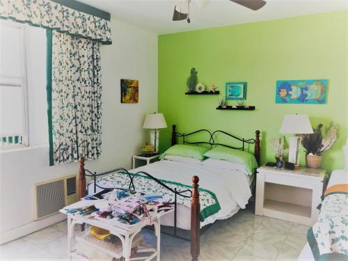ein Schlafzimmer mit einem Bett und einer grünen Wand in der Unterkunft Opp Sea, Beach, Restaurants 5b - 2bed 2 bath 5B Hastings Tower in Bridgetown