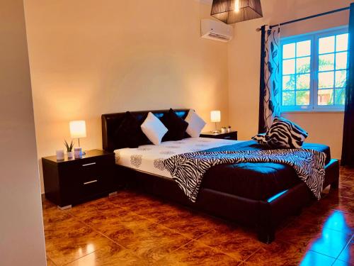 a bedroom with a bed with a zebra patterned sheets at Moradia Correia in Olhão
