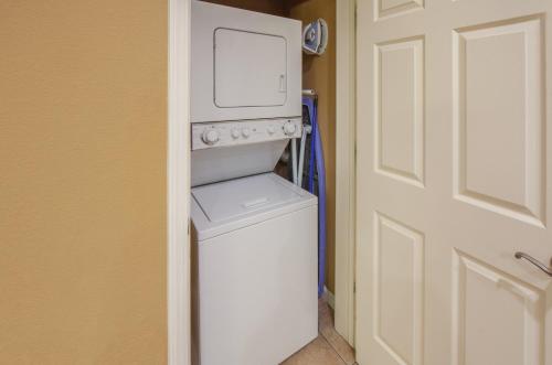 
a small white kitchen with a white refrigerator at Holiday Inn Club Vacations - David Walley's Resort, an IHG Hotel in Genoa
