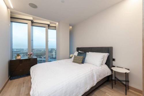 a bedroom with a large white bed and large windows at Amazing Apartment with Incredible Views (MLG) in London