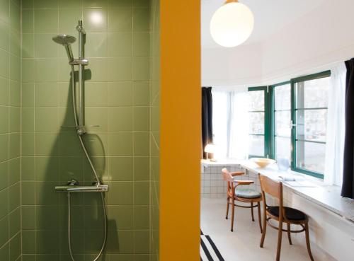 baño con ducha, mesa y sillas en SWEETS - Kattenslootbrug en Ámsterdam
