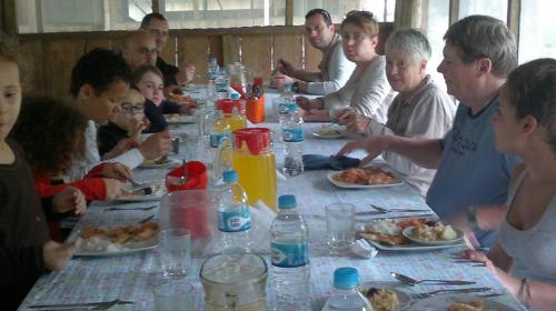 een groep mensen die rond een tafel zitten en eten bij Lodge Jungle Wolf Expeditions in Yucuruche