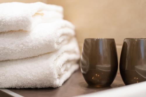 two glasses sitting on a table next to towels at HARBR. hotel Heilbronn in Heilbronn