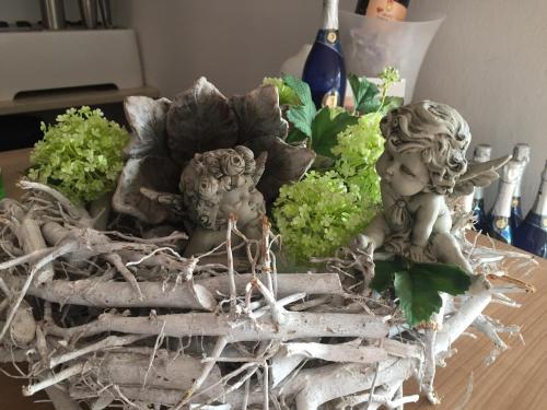 a table with two statues and some plants on it at Pension Zur Alten Post in Havelberg