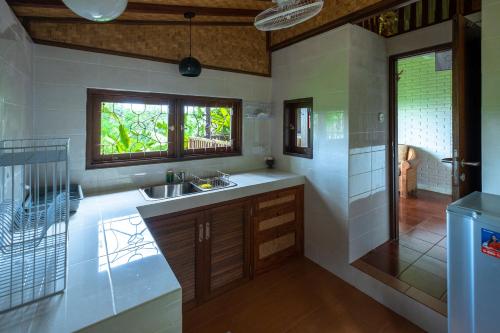 a kitchen with a sink and a window and a shower at Murni's Houses & Spa in Ubud