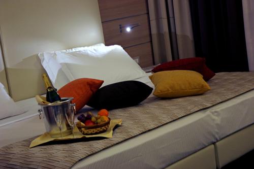 a bed with a bowl of fruit and a bottle of wine at Best Western Plus Soave Hotel in San Bonifacio