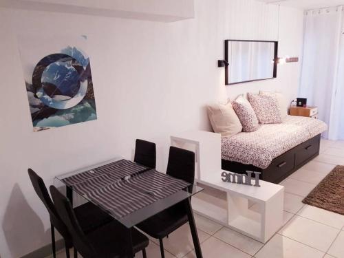 un salon avec une table et un lit dans l'établissement Studio hyper centre, tout confort, à Lourdes