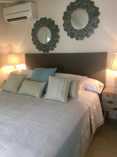a bedroom with a bed with two mirrors on the wall at Sa caseta Farinera in Sóller