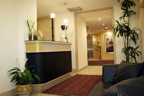 a living room with a large fireplace and plants at Hotel Villa Cibele in Catania
