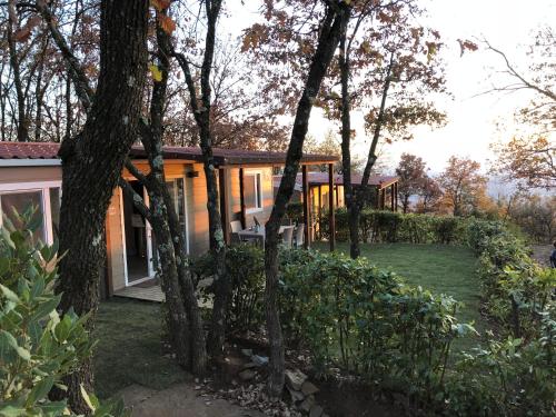a house in the middle of a yard with trees at Camping Barco Reale in Lamporecchio