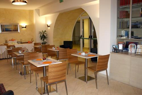 a restaurant with wooden tables and chairs and a counter at Hotel Villa Cibele in Catania