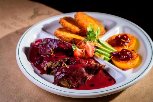a plate of food with meat and vegetables on a table at Gasthof zum Jägerwirt in Mariazell