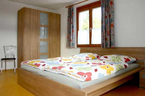 a bedroom with a bed with a wooden frame and a window at Haus Widenhorn in Sipplingen