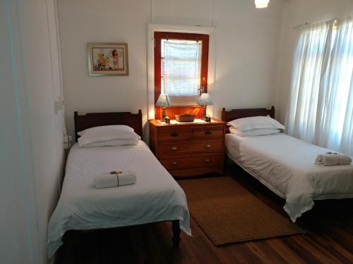 um quarto com 2 camas e uma cómoda e uma janela em Broadview em Sedgefield