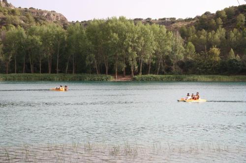 people are riding in boats on a lake at Casa Rural Villa Sem Sem in Ossa de Montiel