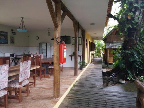 a restaurant with a wooden floor and a table and chairs at Canto do Riacho Suites in Trindade
