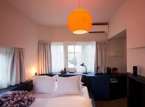 a bedroom with a bed with white pillows and a window at SWEETS - Beltbrug in Amsterdam