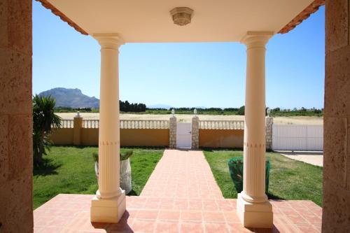 a view from the porch of a house with columns at Finca las Ranas by CARLOSFERIEN in Denia