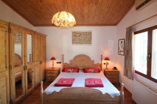 a bedroom with a bed with red pillows and a chandelier at Santa Lucia BA in Denia