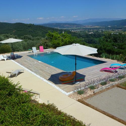 - une piscine avec un parasol, des chaises et une table dans l'établissement B&B L'ESCALADE en Lubéron, à Volx
