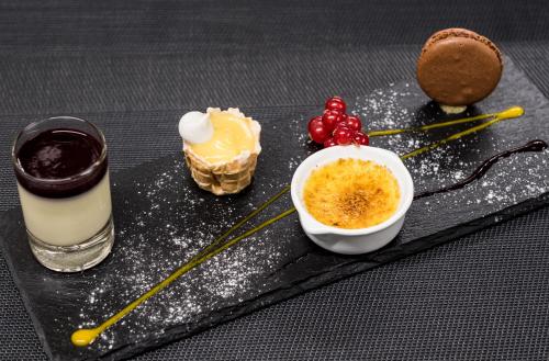 a black tray with some desserts on a table at Hôtel du Cygne in Bevaix
