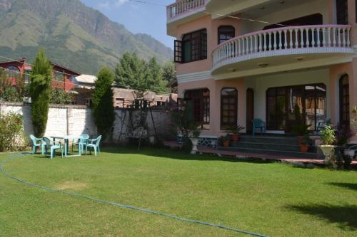 a house with a table and chairs in the yard at Dilaram Guest House in Srinagar