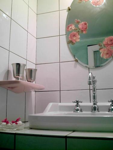 une salle de bain avec un lavabo et un miroir dans l'établissement Domaine du Peyron, à Quintenas